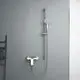 Brausearmatur in Chromfarbe an einer grauen Wand, mit Duschkopf und Halterung, hergestellt von Ideal Standard.